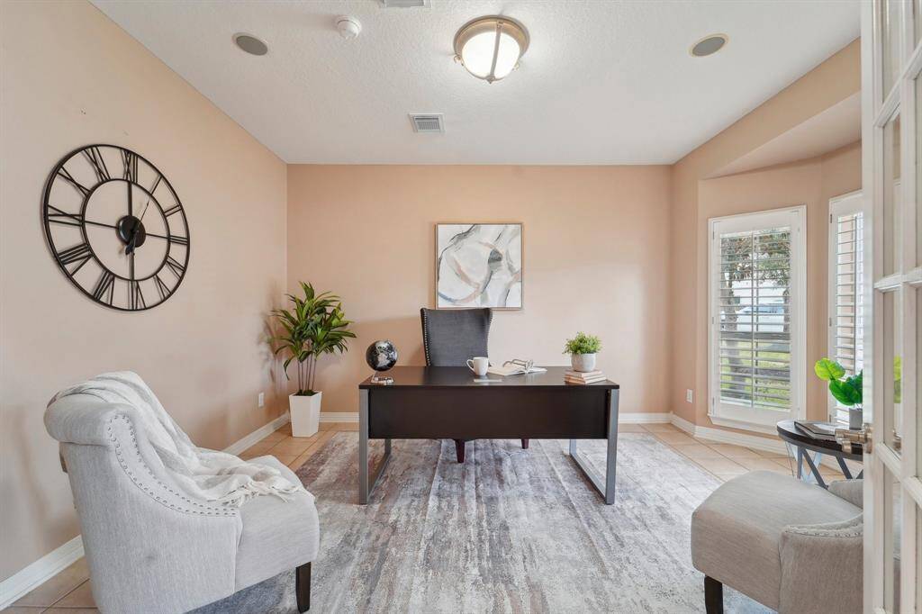 You're going to love the morning commute to this spacious private home office. Tucked behind glass French doors, this study offers tile flooring and neutral paint, wood shutters on the windows, and ample space for your home office furnishings.