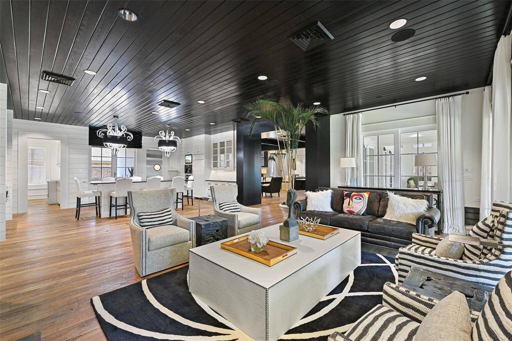 Stately views overlooking the family room, kitchen and beyond into the butler's pantry. The bold contrast between the white, crips walls and dark, moody wood ceilings provide a dramatic and engaging interior.