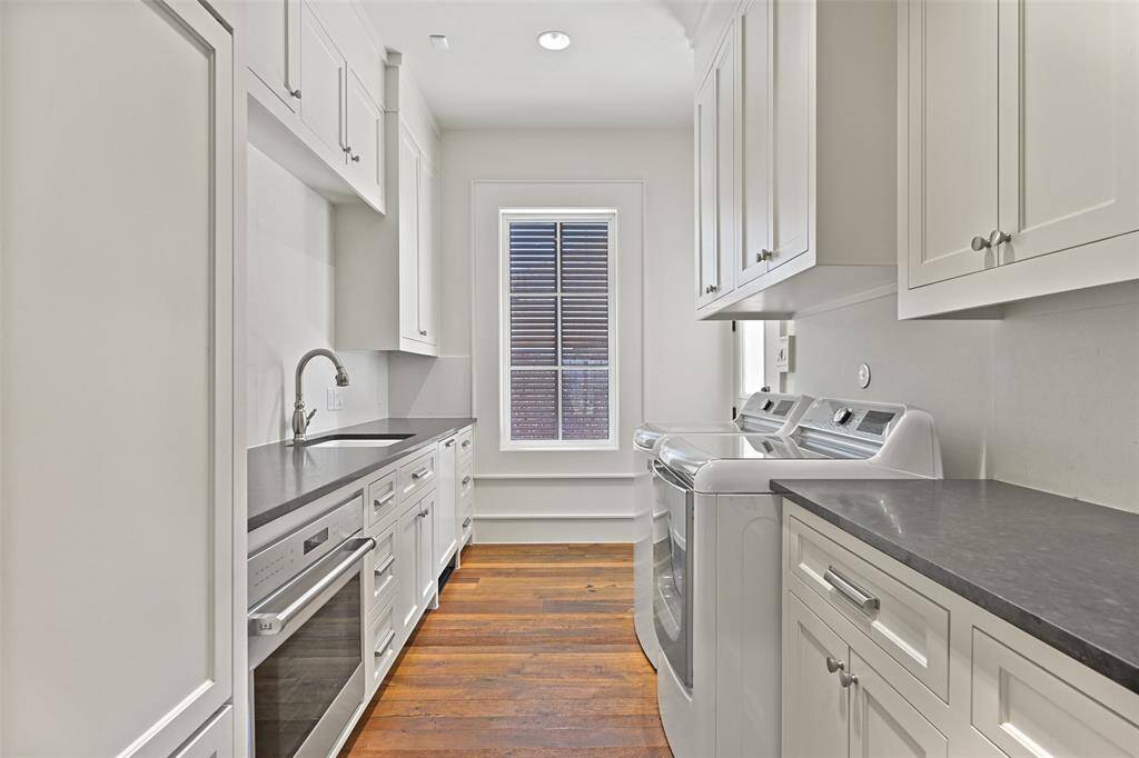 The Butler's Pantry and Utility room space feature a Wolfe electric oven, built-in Sub Zero Refrigerator/Freezer, Miele dishwasher, sink and an abudance of cabinetry for storage. A side entry door leads out to the side patio and driveway space.