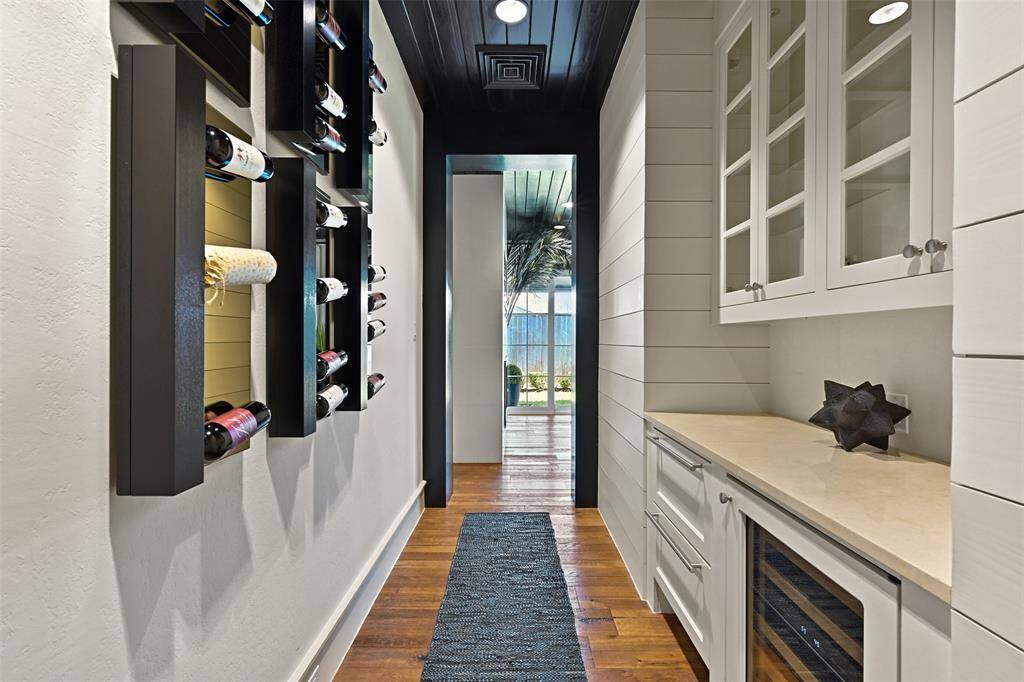 The entrance to the primary suite features a cleverly designed space featuring a Sub Zero wine cooler, 2 refrigerated drawers, wine rack wall feature and a stunning first look into the retreat.
