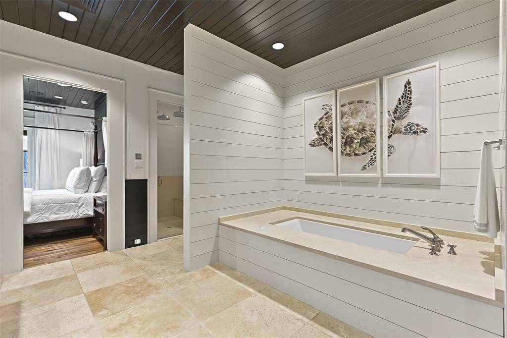 Timeless travertine floors provide an elevated and spa-like retreat with a large walk-in steam shower featuring rain heads, and 1 1/2" water lines to the house to enhance water pressure.