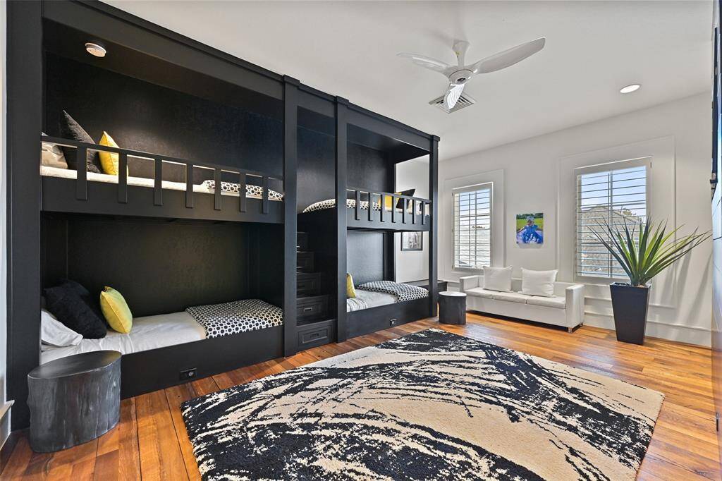 A striking view of the Bedroom 3 or the Bunk room with custom bunk beds with ladder for easy accessibility, sleek fan, high ceilings and lovely plantation shutters.