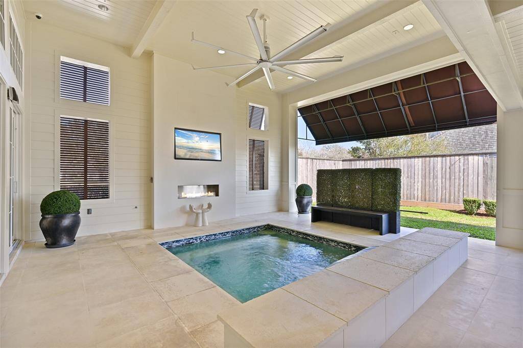 Overlooking the sparkling plunge pool and surrounded by lush greenery and outdoor fireplace, the patio offers a seamless connection between the indoor living spaces and the serene outdoor environment. Ideal for relaxing or hosting, it's a true extension of the home's sophistication.