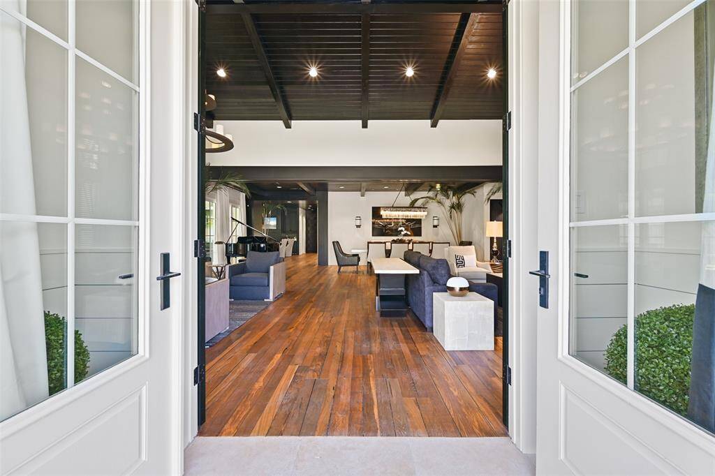 The grand double doors make a bold statement of luxury and sophistication. Featuring a striking set of black Bermuda shade style doors. This entryway sets the tone for a home that is perfectly balanced with contemporary refinement.
