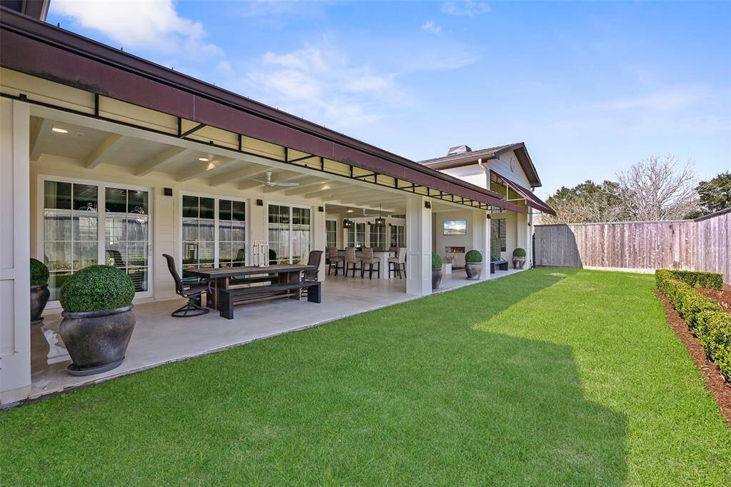 The stunning side yard features lush landscaping and incredible views of the expansive outdoor patio, plunge pool and side elevation of the home.