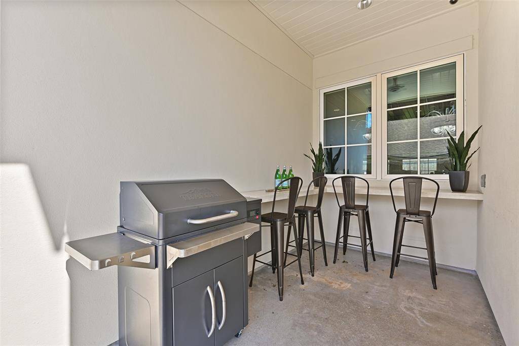Clever and function side patio off of the side entry with room for a grill or smoker, granite corner wraparound bar area with room for seating.
