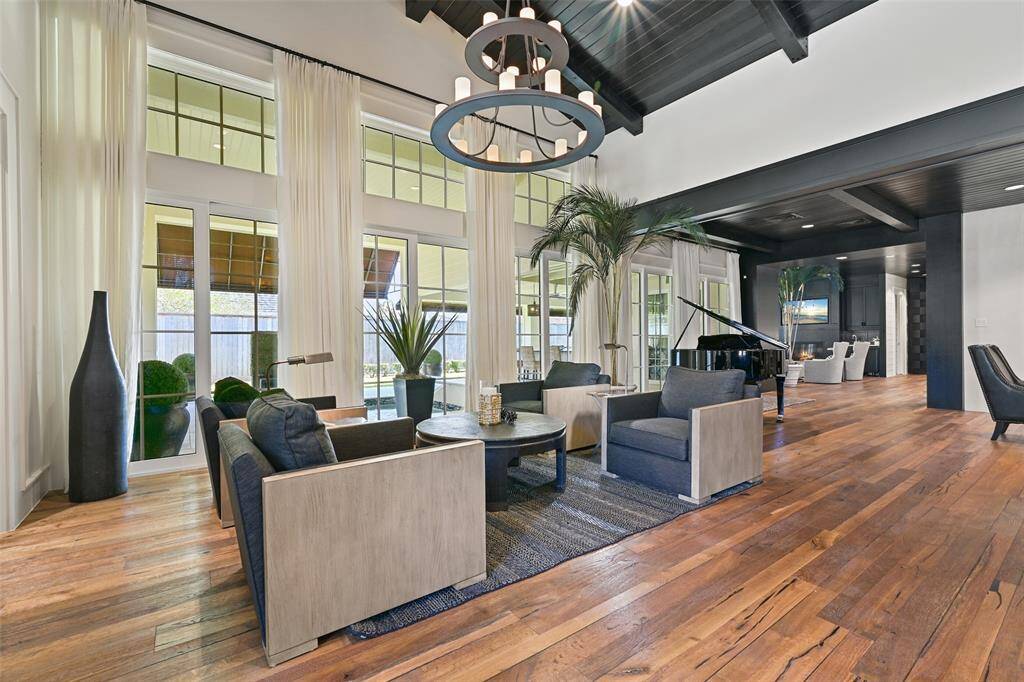 A second majestic seating arrangement showcases floor to ceiling impact resistant windows and doors. Elegant details, such as the crisp white walls, trestled oak reclaimed wood floors from England and expansive spaces to enjoy for everyday living and entertaining guests.