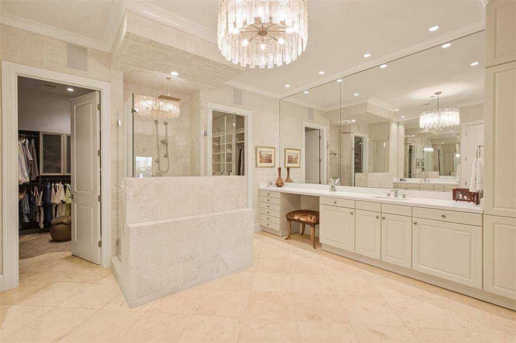The area in front of the shower is plumbed for a vessel tub. Note the seated vanity and custom cabinetry.
