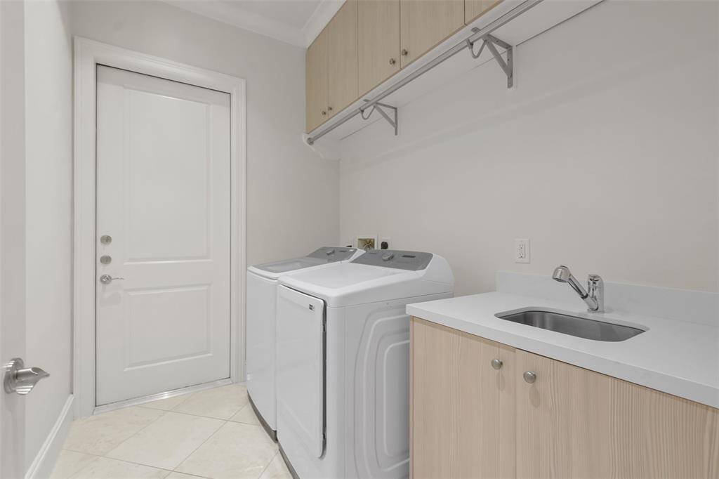 The utility room includes sink and drip dry hanging space as well as access to the mechanical corridor. Note the upper cabinet storage.