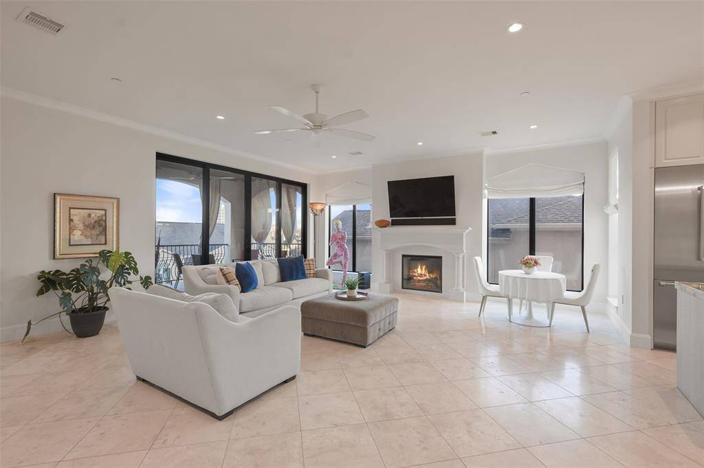 The living areas are spacious and offer a faux-fireplace, stone floors and easy access to the large covered balcony from the double sliding glass doors.
