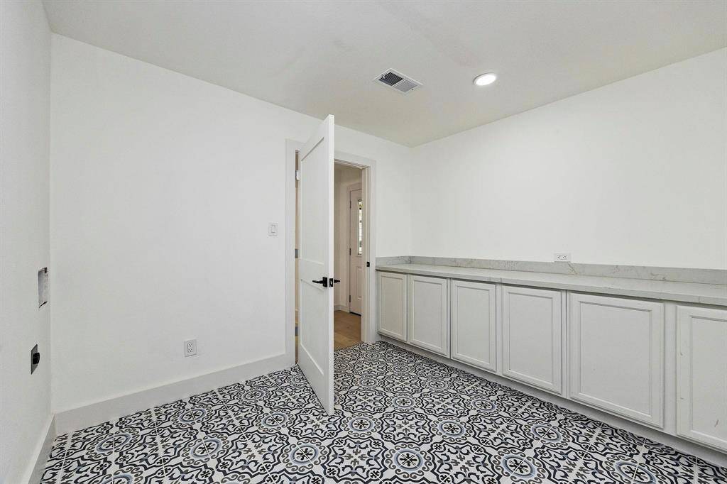 Conveniently tucked away off the kitchen, is the expansive laundry room! There is plenty of storage space with the custom built ins, plus additional space for an extra fridge or freezer.