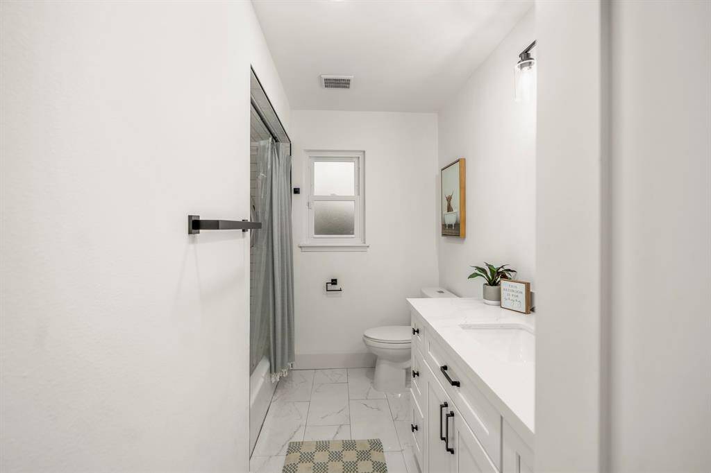 Relax and unwind in this beautifully designed secondary bathroom, featuring elegant quartz countertops and a spacious combination tub and shower for the ultimate in comfort and style.