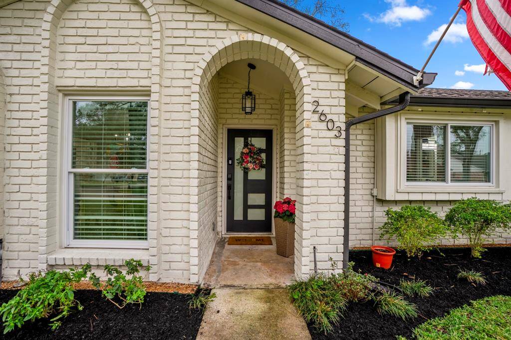 Approaching the front door you see the beautiful elevation, lovely landscaping, covered front porch, modern porchlight, and contemporary front door with privacy glass. It's completed with keyless entry and a smart doorbell.