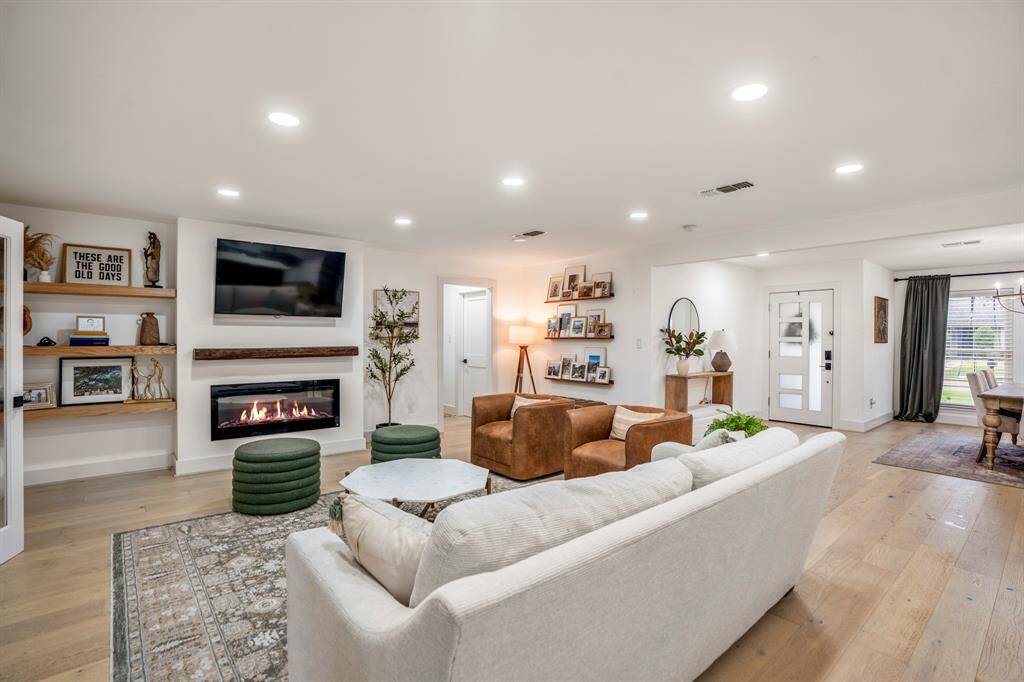 Imagine hosting the next holiday or social event in the perfect living space! You'll love cozying up by the fireplace, complete with a sleek wood mantle, decorative art niche to the left, and floating shelves. This room can fit any size tv making it great for the next big game or movie night.