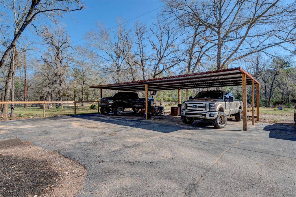 4 car carport is located in front of the log cabin.
