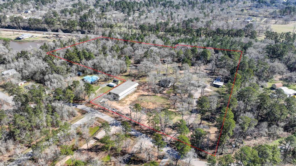 You can see the covered unfinished barndominium. The log cabin is under the trees in the middle of the property.