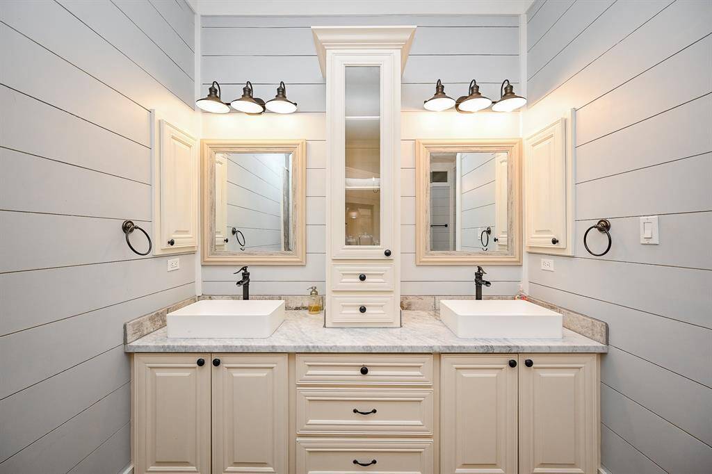 The primary bath is complete with dual sinks, granite counter tops, dual mirrors and abundant storage.  Shiplap and designer lighting complete the look of this room.