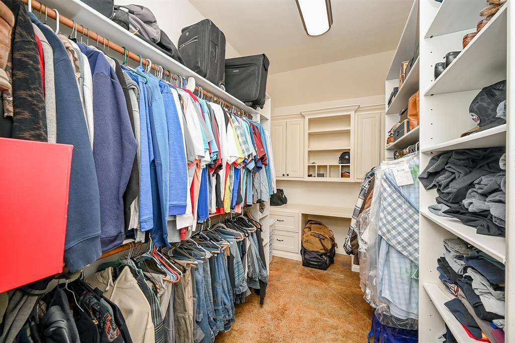 Another great feature of this home is the large walk-in storage closet.  What sets this home apart is the this is for him!  This room is complete with shelves, rods, drawers, and cabinets.