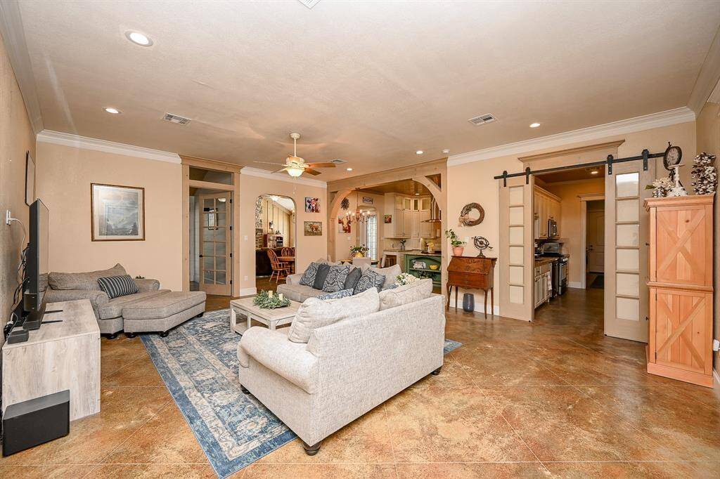 Upon entry you immediately are greeted by a large family gathering area. Recessed lighting, ceiling fan, painted concrete flooring and an open and warm feeling are created from the moment you enter. To the right, set apart by barn doors, is the "generational" area of the home. This creates an atmosphere of both family inclusion and the independent living that may be sought.