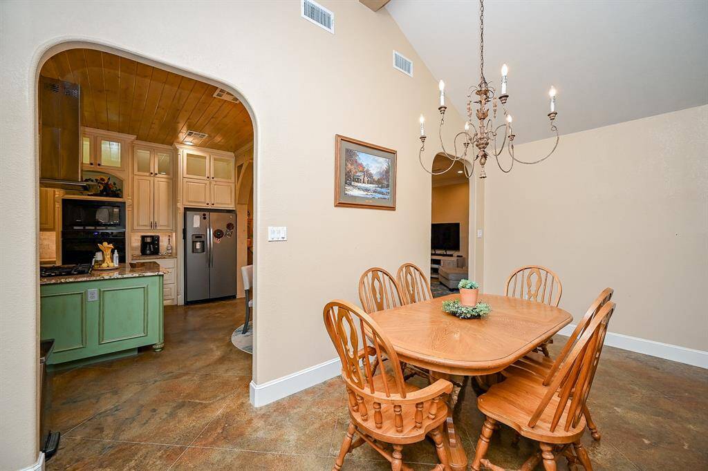 Need room for a more formal family meal?  A second large family gathering area allows for a comfortable gathering with easy access to both the kitchen and the family room.  Again, painted concrete flooring and a vaulted ceiling add to the decor of this area.