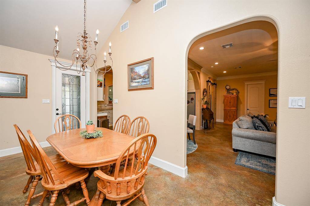 Viewed from another angle, this larger family gathering area features direct access to the covered outdoor patio and outdoor kitchen and dining through a designer door.