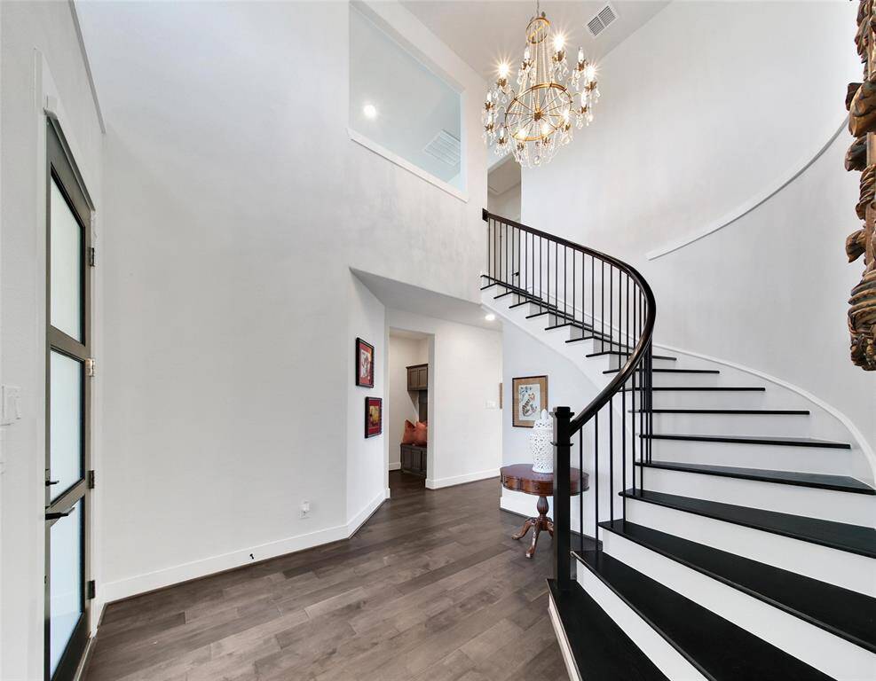 One step inside and the rave reviews begin! The sweeping staircase with wood treads and elegant chandelier instantly captivate!