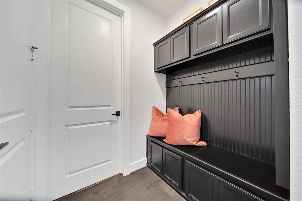 This "Mud Room"  with espresso colored Tree Bench with storage is conveniently located between the garage entrance and utility room. Your jackets, backpacks, and shoes now have a home too!