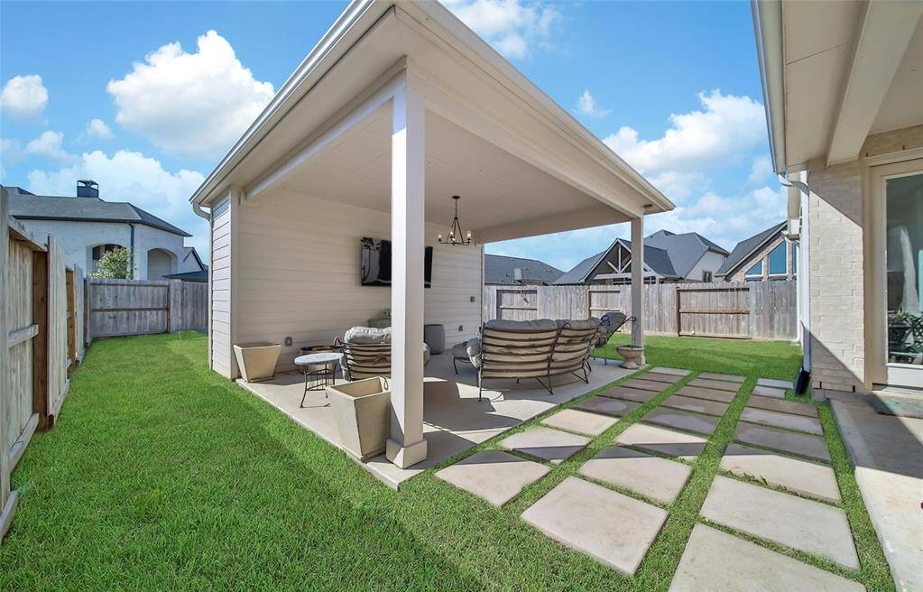 Pavers lead into a 14' x 18' freestanding patio with hip style roof with hardie plank ceiling.