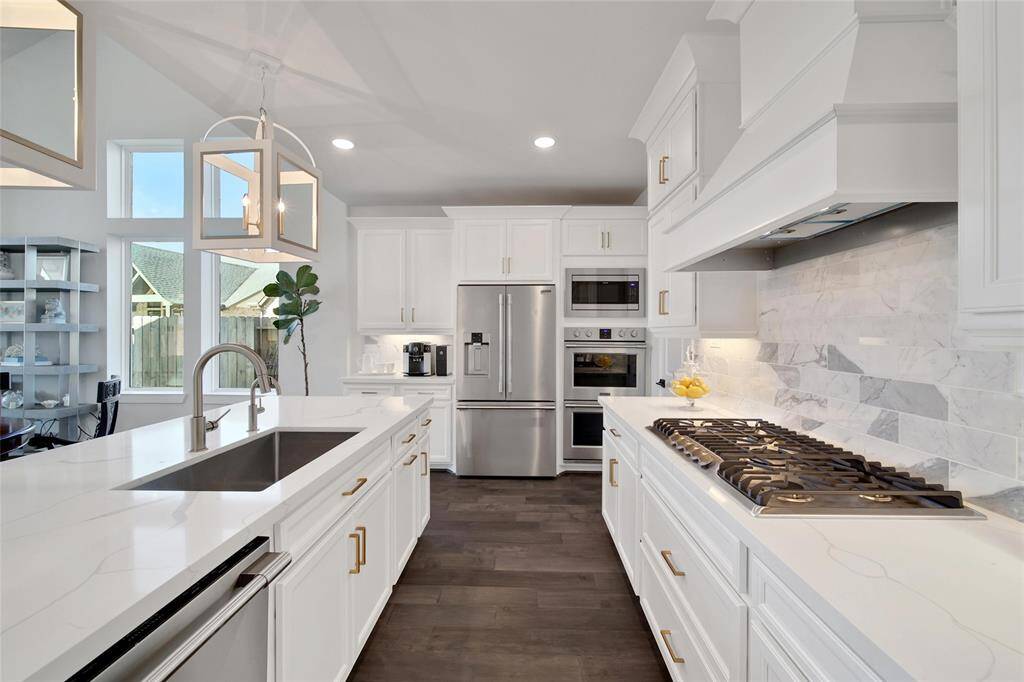 This Kitchen has it ALL!Gorgeous porcelain countertops are accented by the marble calcutta gold backsplash that is showcased by the under cabinet lighting.