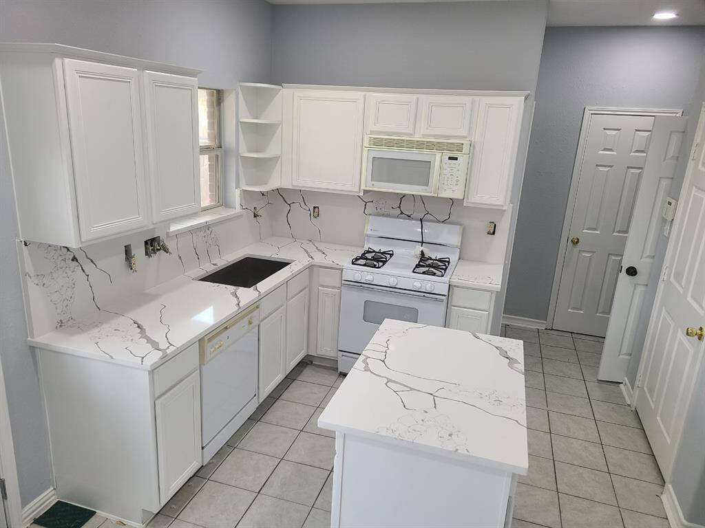 Elegant quartz countertops and backsplash enhance this kitchen’s modern appeal.