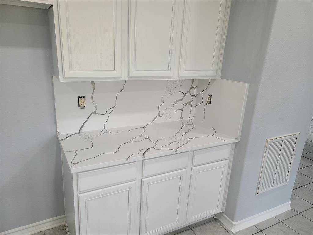 Elegant white cabinetry paired with sleek, modern countertops.