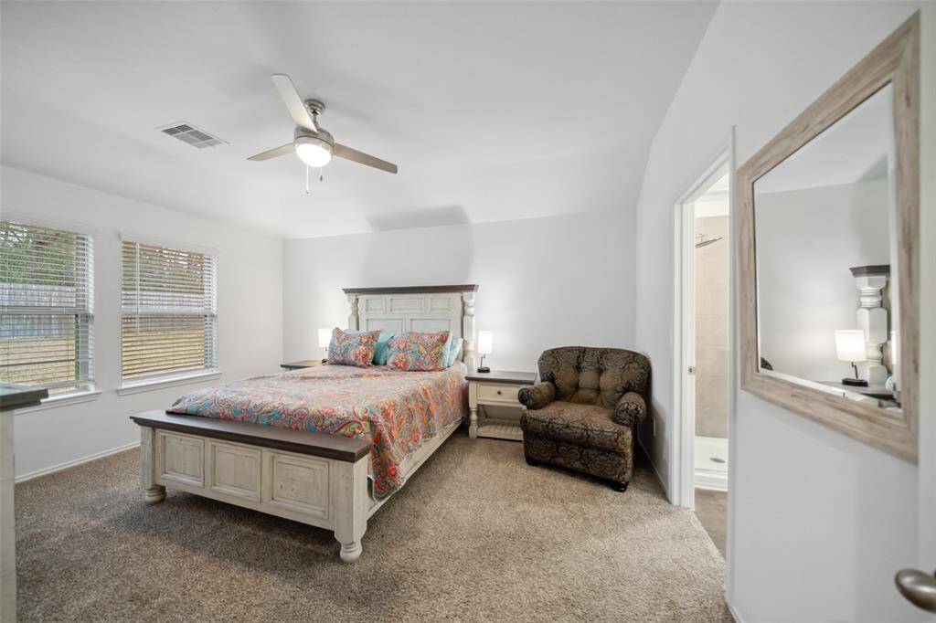 Entry into the primary bedroom is furnished with a queen bedroom set and sitting chair.