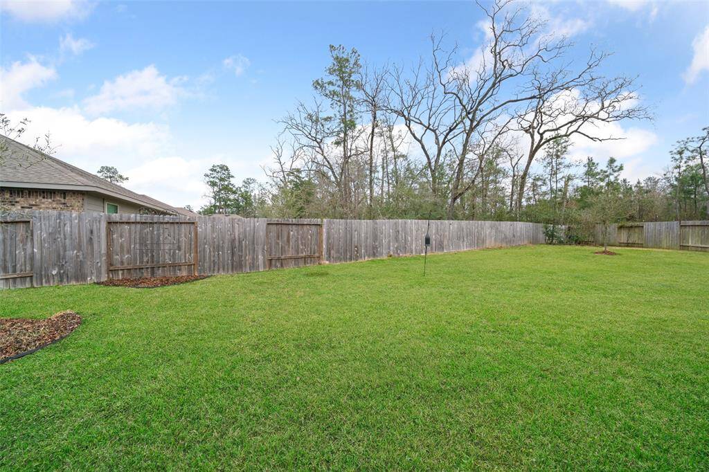Huge backyard is fully fenced and backs up to woods.
