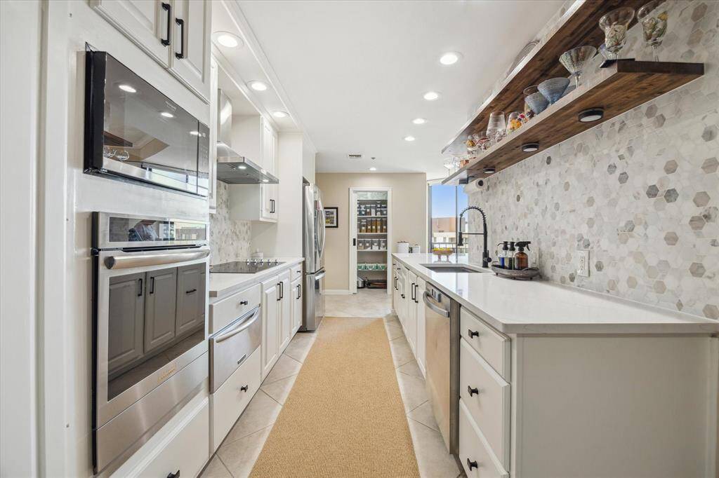 Pullman style kitchen features recent appliances, lots of counter space and storage cabinets plus additional pantry space. The walk-in pantry is seen at the far back --