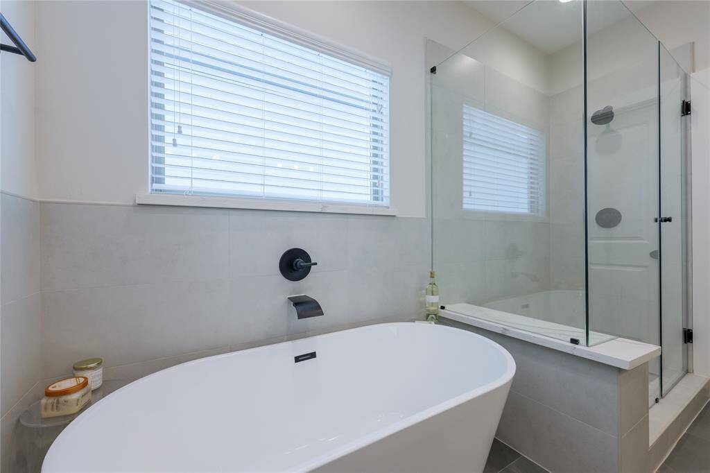 Separate soaking tub and stand alone glass shower.
