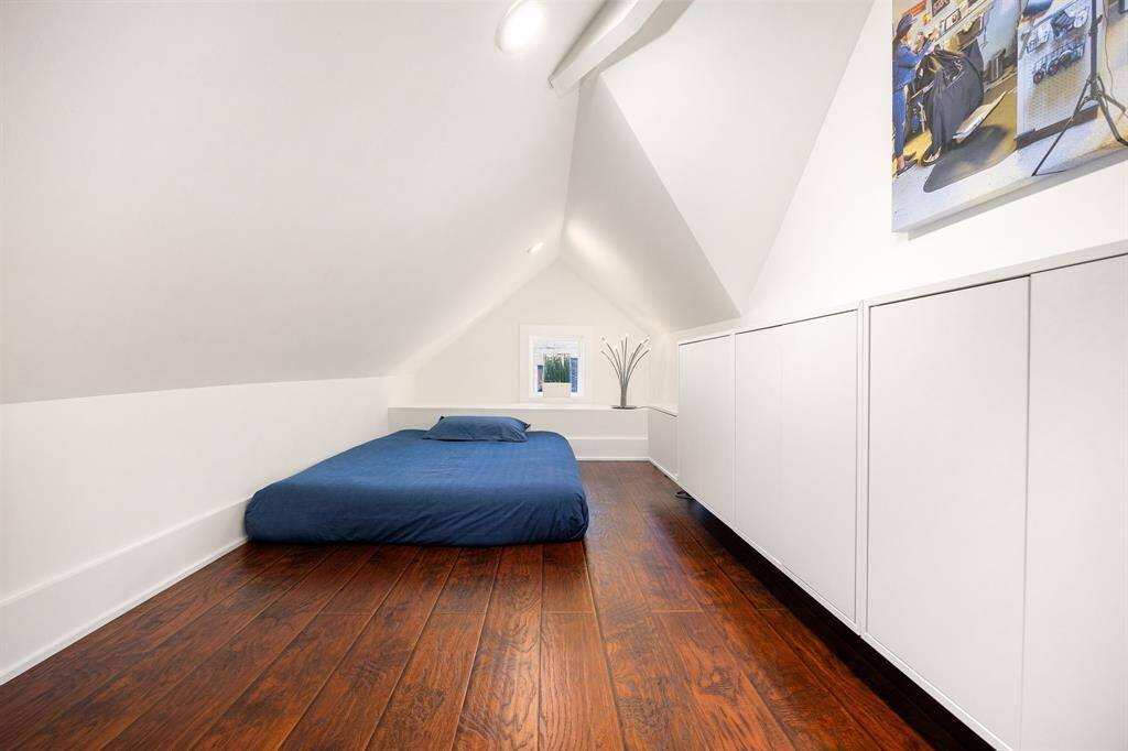 Upstairs bedroom features a charming nook tucked away within the oversized  room to create a cozy, private sleeping area—perfect for relaxation and restful nights.