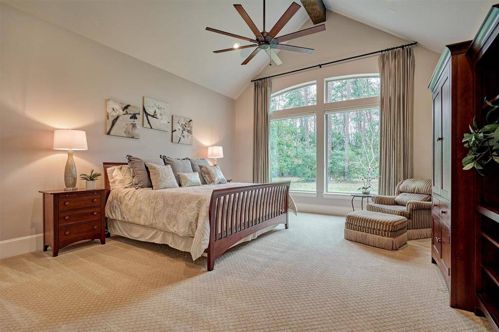 Primary Bedroom with large windows looking out to private backyard space.