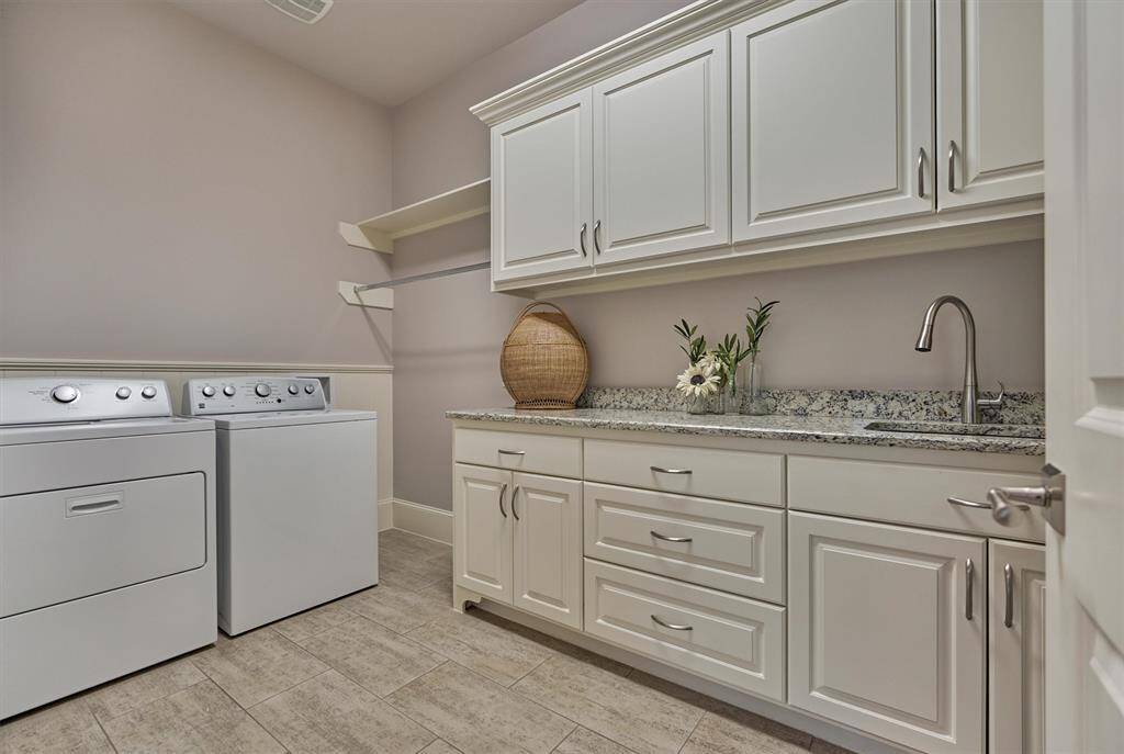 Oversized utility/laundry room with sink and plenty of storage.