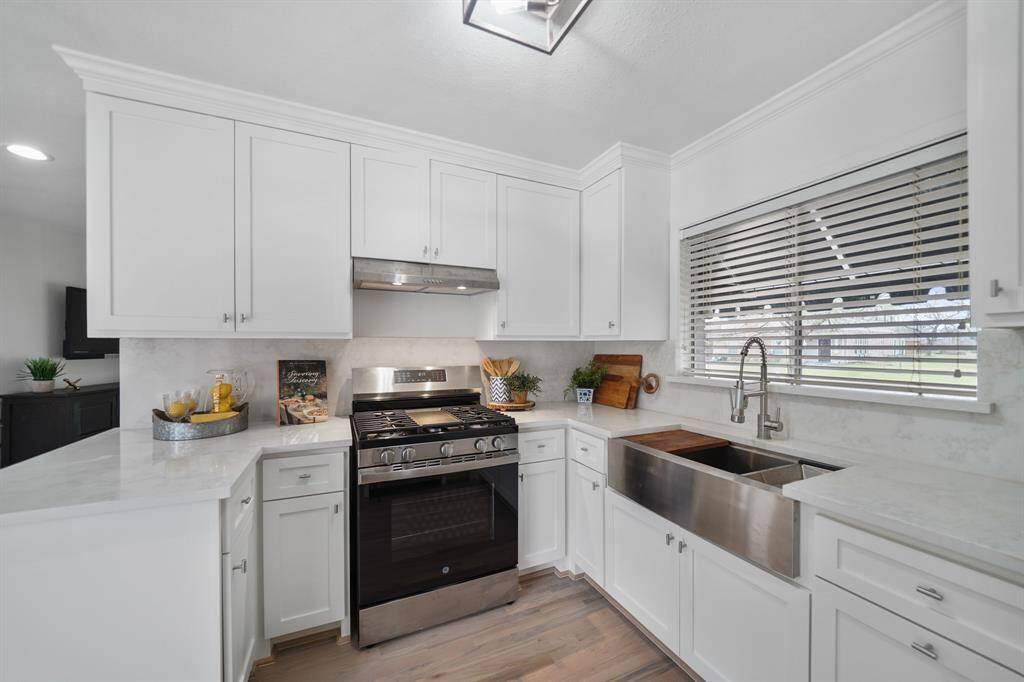 Installed in 2024, the GE stainless steel appliance package includes a 4-burner gas range with griddle & conventional oven below with ventilation and lighting above and a dishwasher.