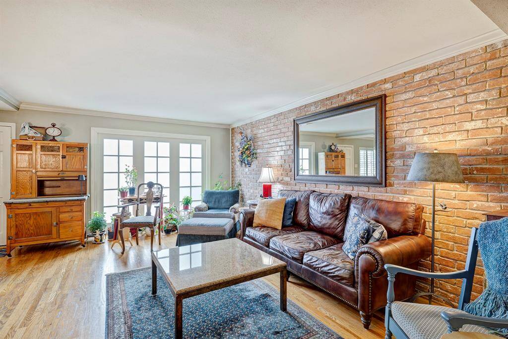 A huge wireless TV can be put on the brick wall and furniture rearranged