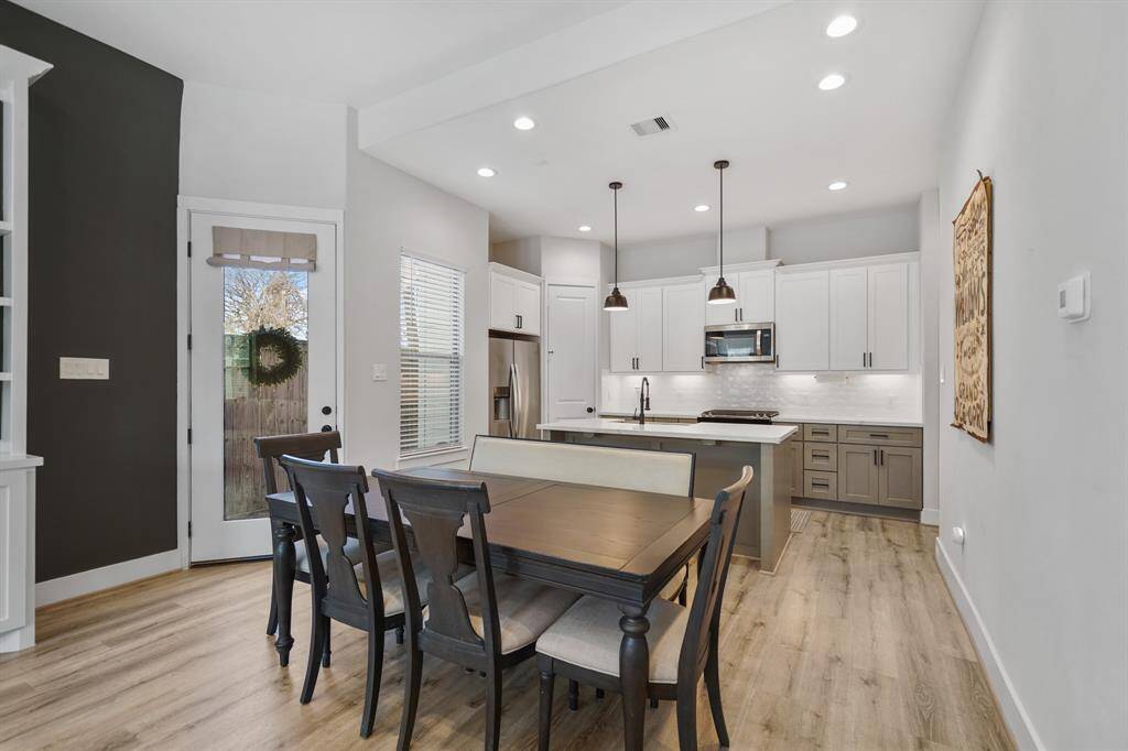 The formal dining room includes recessed lighting, pre-wiring for chandelier lighting, a window with blinds overlooking the front porch & luxury vinyl plank hardwood flooring.