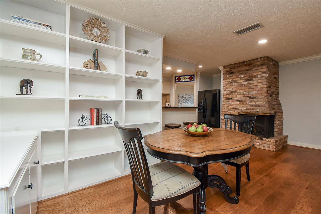The cozy breakfast area is situated next to the family room, featuring a round table and comfortable chairs. Large windows and built-in shelves add to the charm, making it a perfect spot for casual meals.