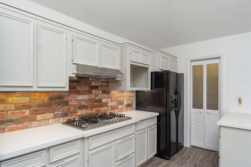 The home is just so authentic with a great vibe. The brick against the white cabinets is a great look