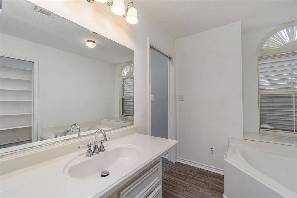 The primary bathroom has a jetted tub and separate shower with a large walk in closet