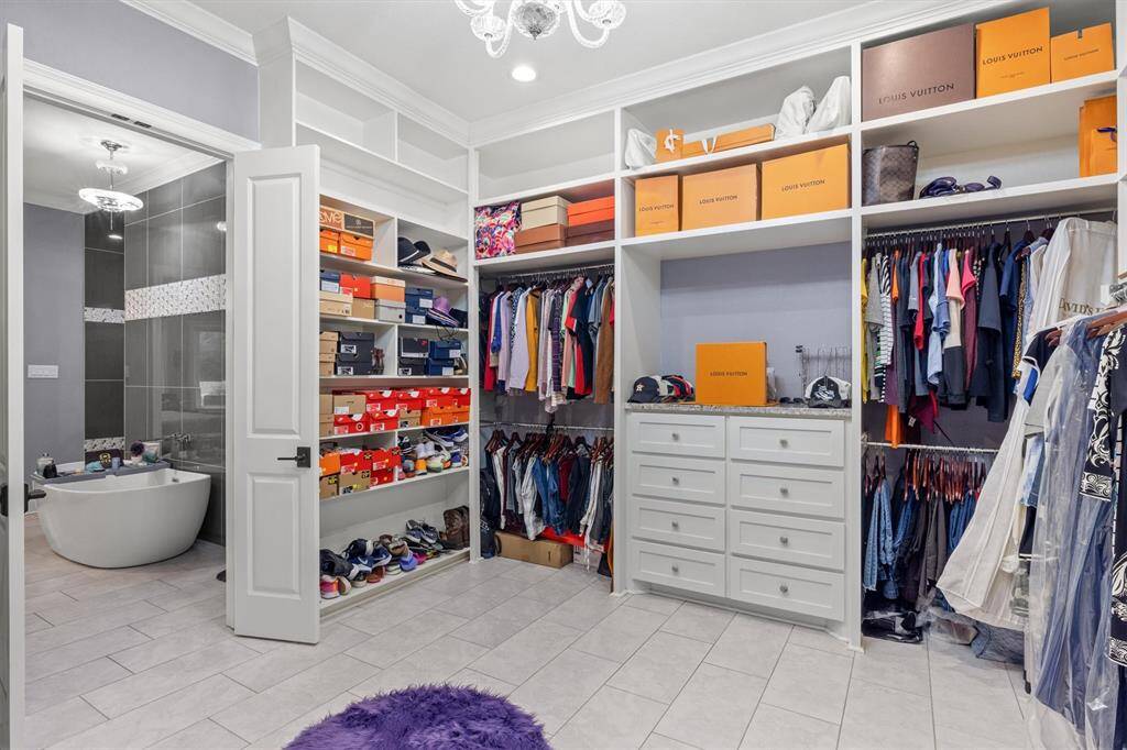 Walk in primary closet with chandelier and built-ins!