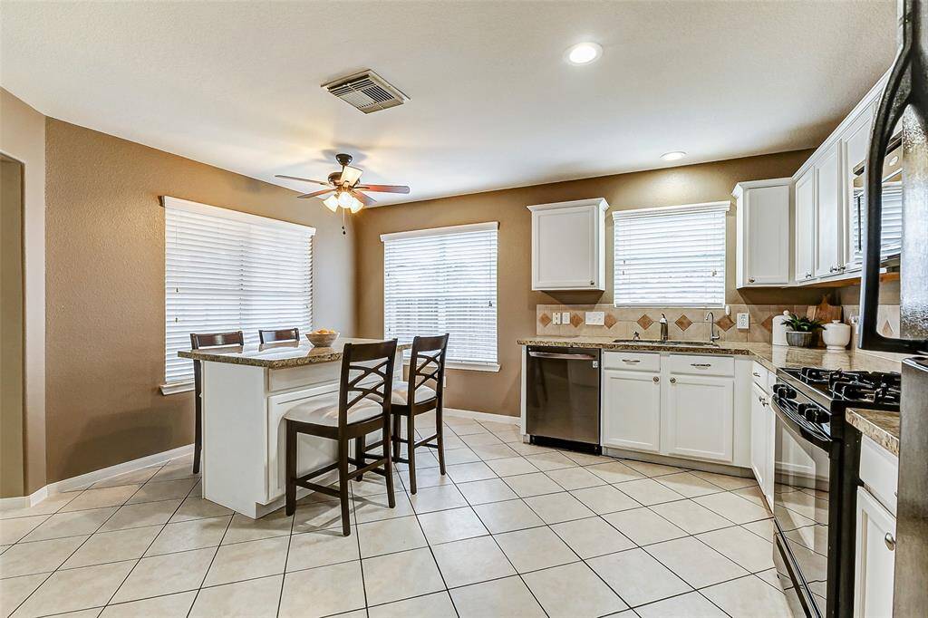 The kitchen has been updated with white cabinets and granite counters.