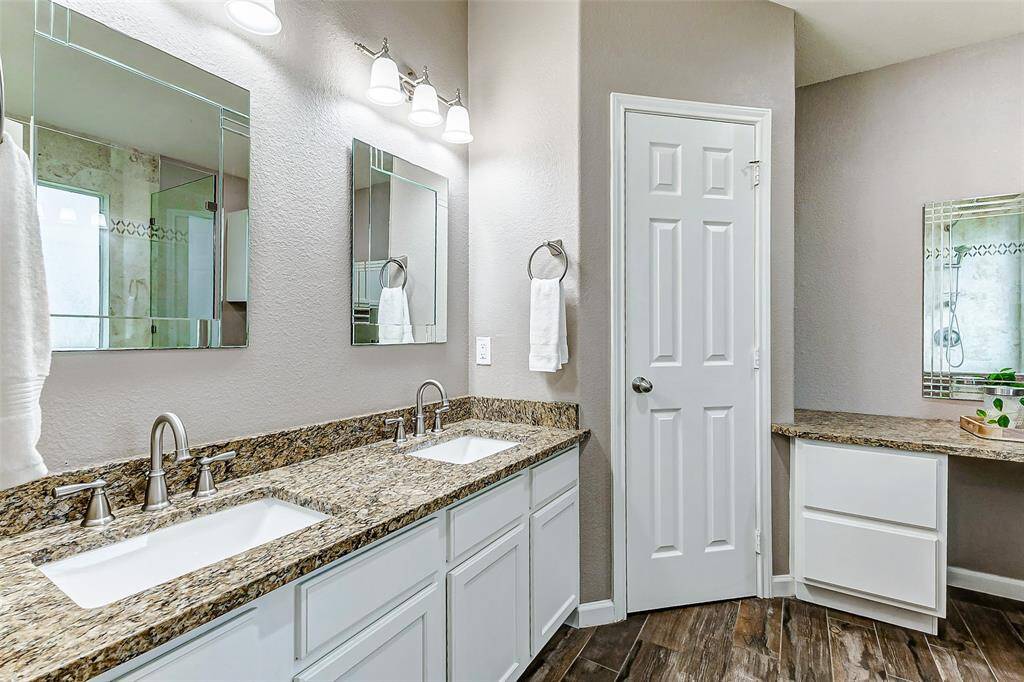The primary bathroom has been updated with granite counters, white cabinets and an updated shower.