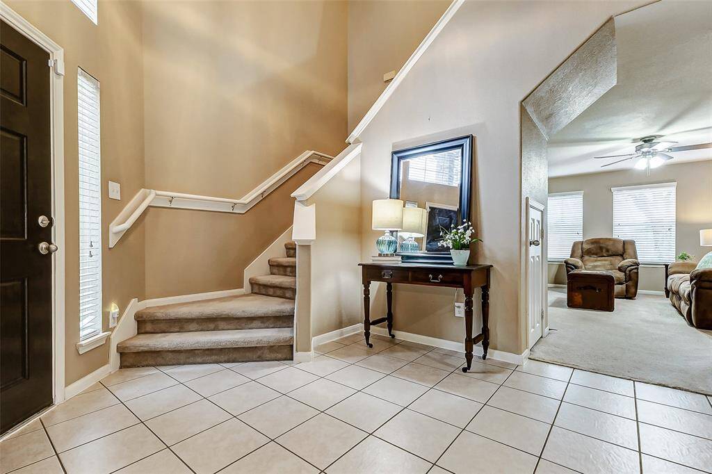 The entry features soaring ceilings and tile flooring.