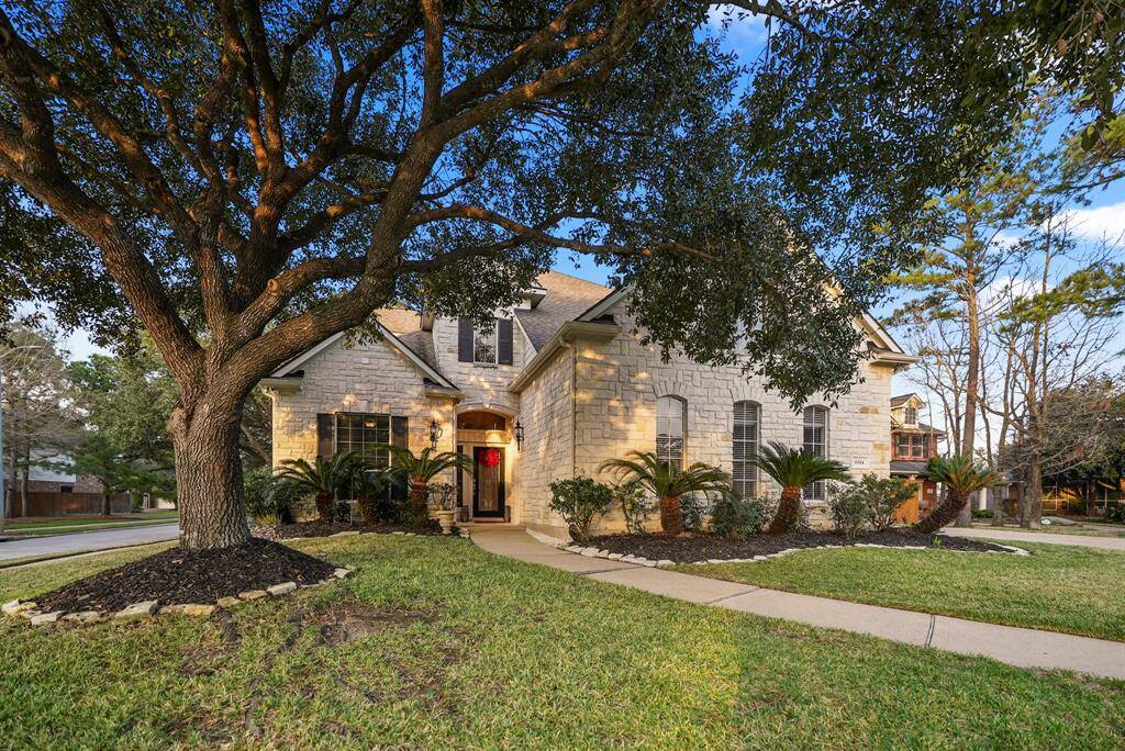 Stunning curb appeal with beautiful white limestone masonry, dark shutters, and a mature oak tree providing shade and character. This elegant home sits on a corner lot, offering both charm and privacy.