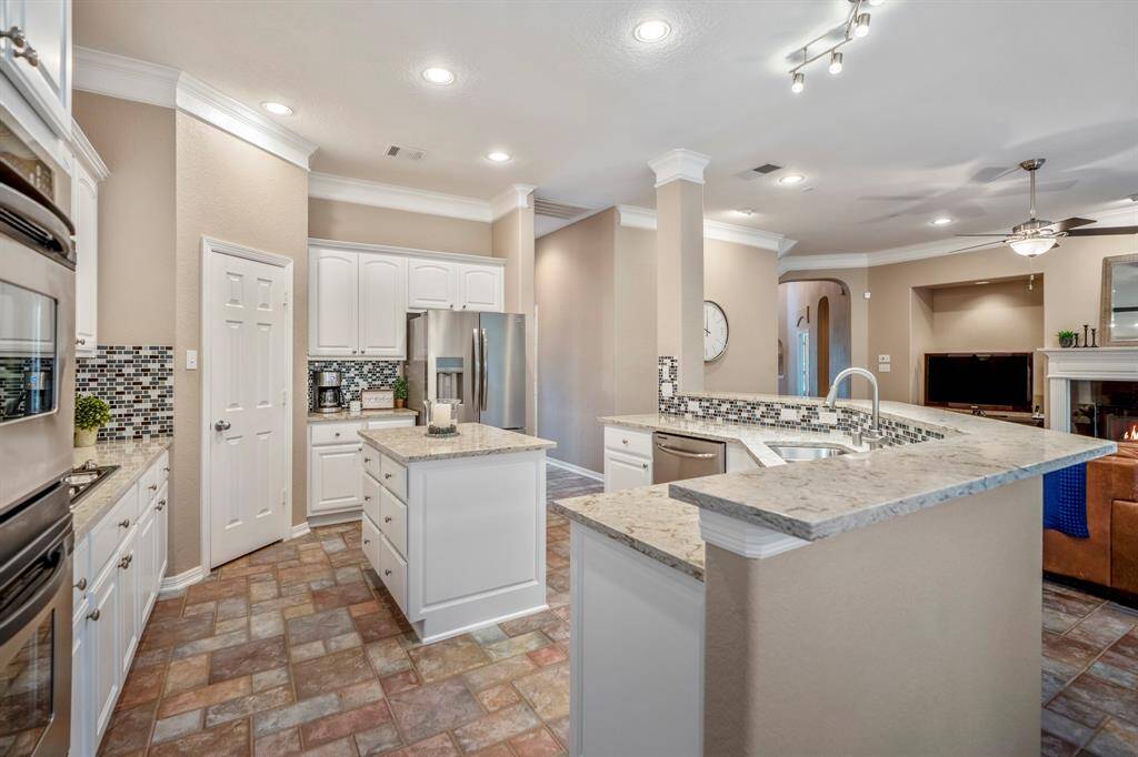 From this angle, you can truly appreciate the ample storage in this kitchen, including convenient drawer storage in the middle island and a coffee bar area near the fridge. Every corner of the space is designed for maximum functionality, offering plenty of room for all your culinary needs. The thoughtful design and layout make this kitchen not only beautiful but also incredibly practical.
